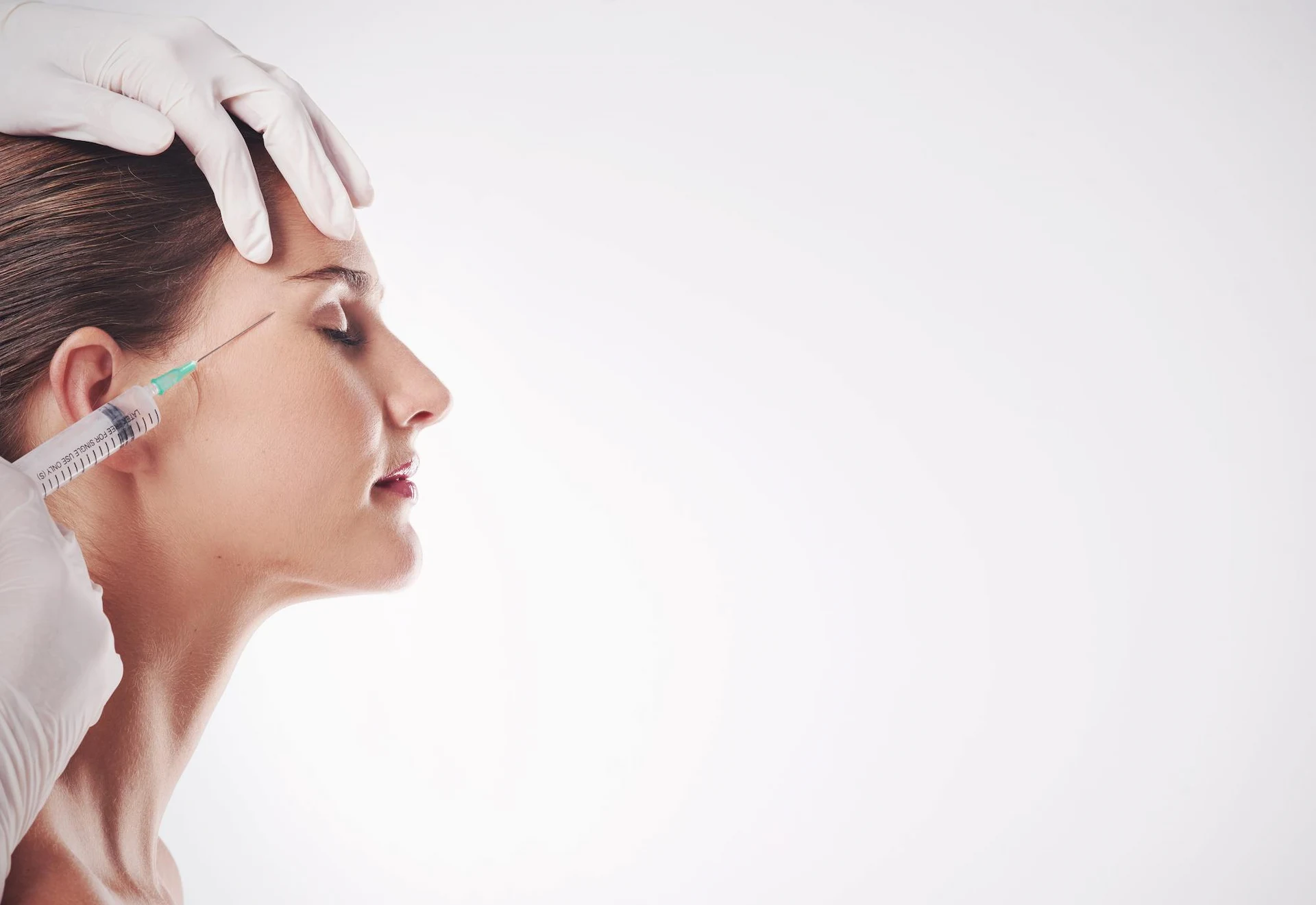 Mujer aplicándose un tratamiento facial antiedad en la Clínica Fernández Blanco