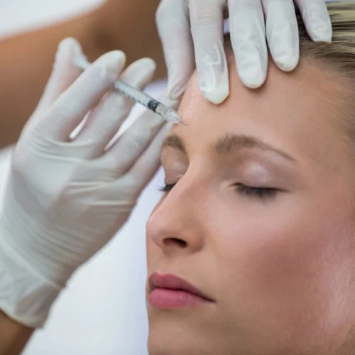 Woman receiving full face-type facial treatment with injections in Marbella.